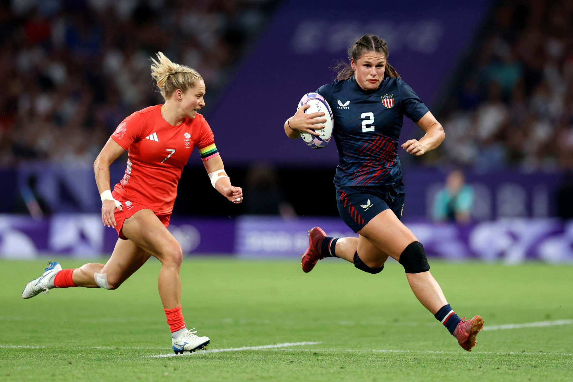 A rugby player carrying the ball past a defender
