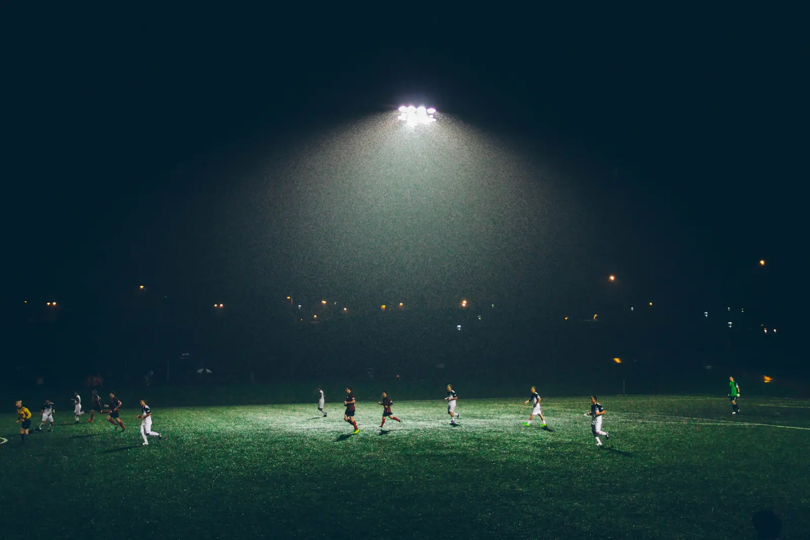 A soccer match under stadium floodlights at night